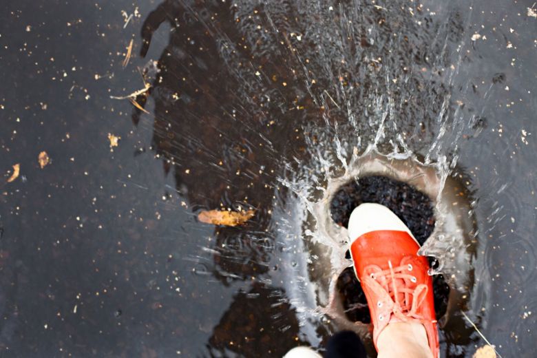 Kenkä astuu vesilätäkköön.