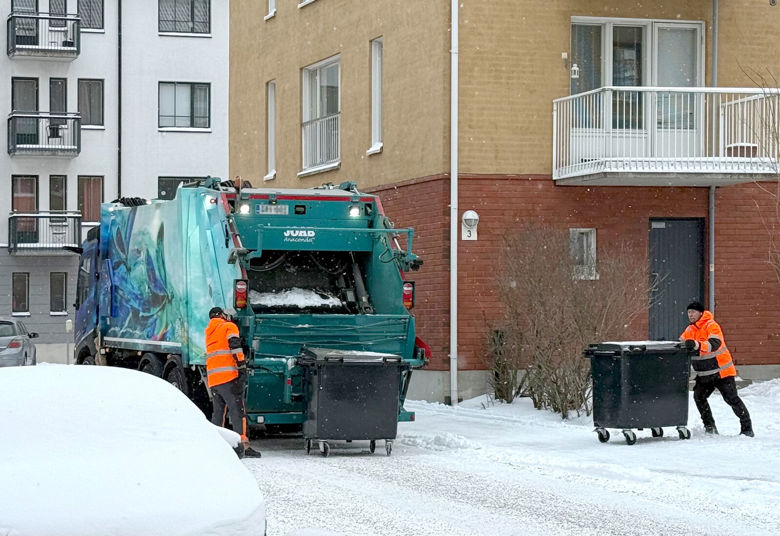 Jäteautoon tyhjennetään jäteastioita talvisessa kaupunkiympäristössä.