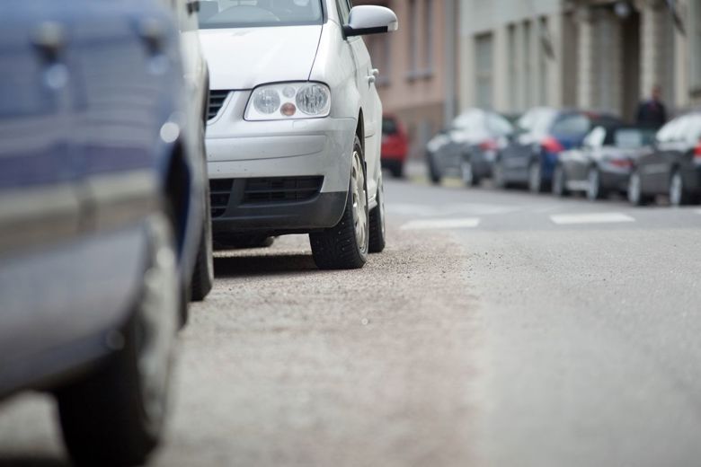 Autoja kadulla, jossa on runsaasti hiekoitussepeliä.