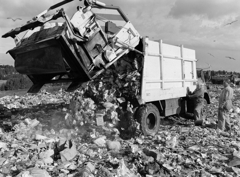 Jäteauto tyhjentää kuormaa Talin kaatopaikalla vuonna 1976. Mustavalkokuva.