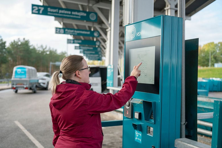 Sortti-aseman asiakas käyttää itsepalvelulaitetta.