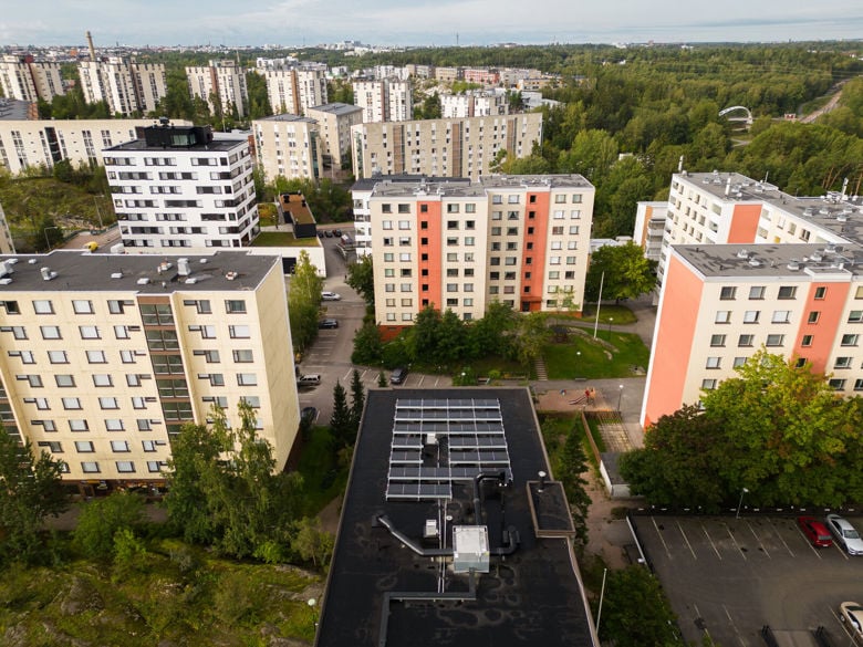 Ilmakuva kerrostaloista, joita ympäröi vihreä puusto.