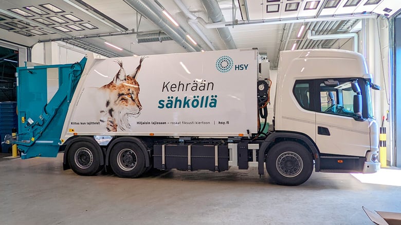 Sähköinen jäteauto, jonka kyljessä ilveksen kuva ja teksti