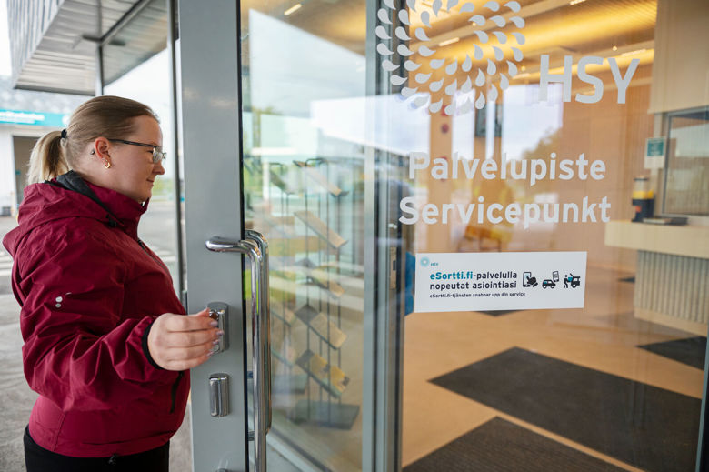 Asiakas astuu sisään Sortti-asemien palvelupisteen ovesta.