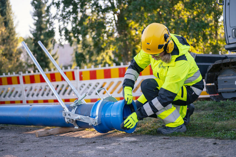HSY:n vesihuollon työmaalla työntekijä tarkastelee putkenpätkää.