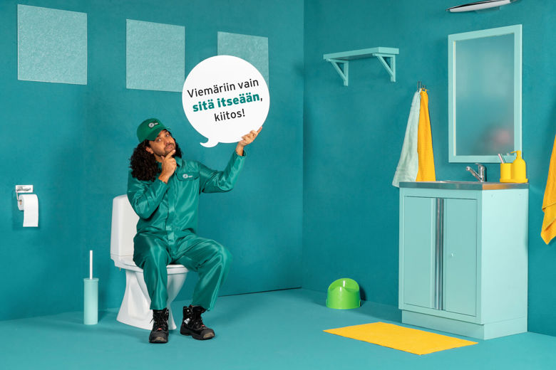 HSY-hahmo istuu wc-pöntöllä ja pitää kädessään puhekuplaa.