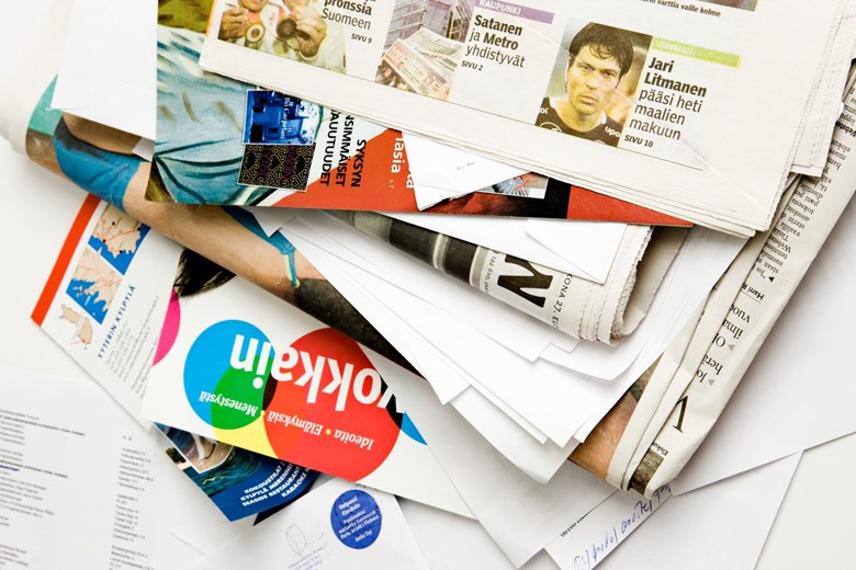 A pile of Finnish-language newspapers and papers. 