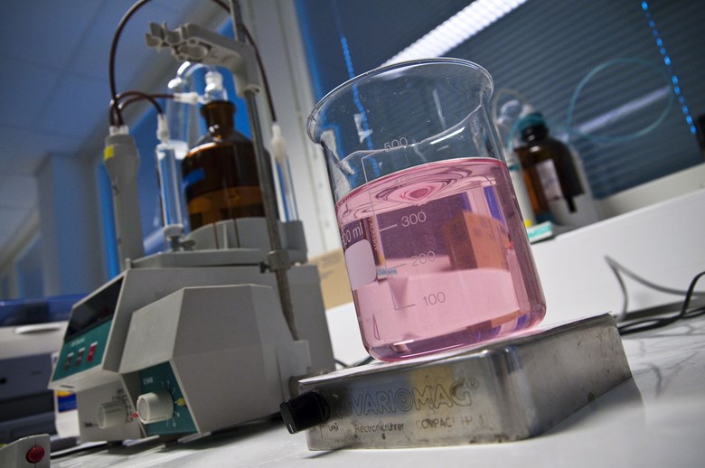 Laboratoriossa on vaaleanpunaista liuosta keitinlasissa.